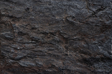 Close-up of a dark slate rock texture, ideal for use in backgrounds, design elements, and nature-related themes.