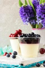 Italian dessert pana cota with berry jam and fresh blueberries