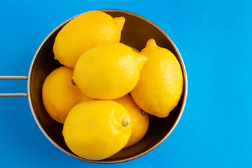 青い背景にボールに入った黄色が鮮やかなレモン
