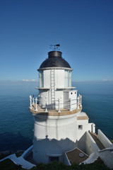 Fototapeta na wymiar White lighthouse with a blue sky in a sunny day