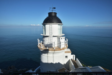 Fototapeta na wymiar White lighthouse with a blue sky in a sunny day