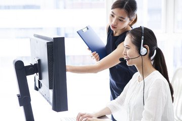 笑顔でにこやかな雰囲気で上司から説明を受ける新人会社員