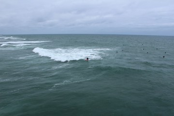 Surfers in the ocean waiting for waves on overcast day