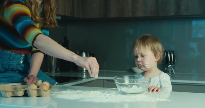 Mother and child putting flour in a bowl