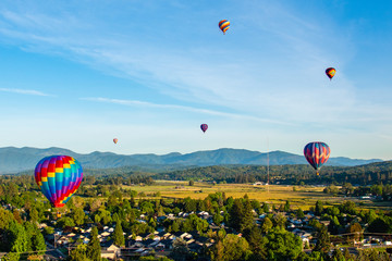 Six Hot Air Balloons Flying Over Town to the Grants Pass Balloon & Kite Festival