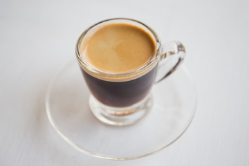 Espresso coffee in glass cup, on a white background.