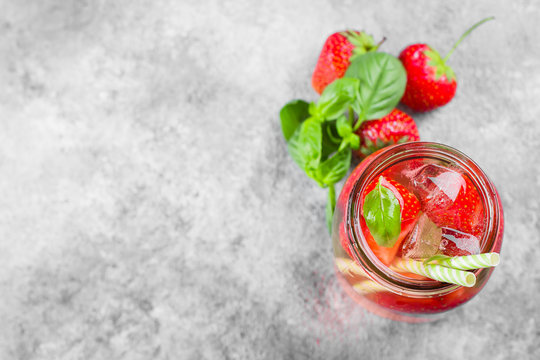 Summer Food and Drink Background. Strawberry lemonade with basil in mson jar on concrete table. Top view, copy space