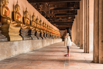 child girl vipassana meditation at front of Buddha statue