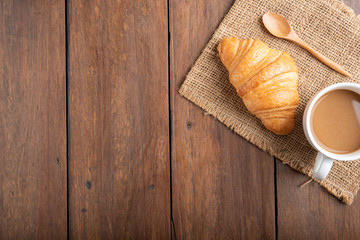 Fototapeta na wymiar Coffee and croissant on wooden background
