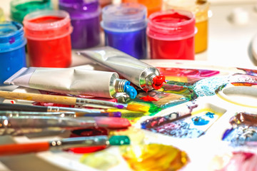 Palette of the artist with oil paints and brushes for drawing. close-up as an artistic background.