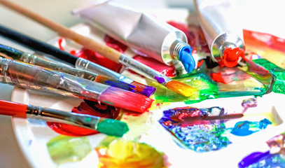 Obraz premium Used palette of the artist with mixed colors of acrylic paints close-up as an artistic background.