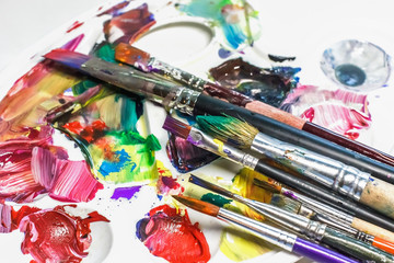 Obraz premium Palette of the artist with oil paints and brushes for drawing. close-up as an artistic background.