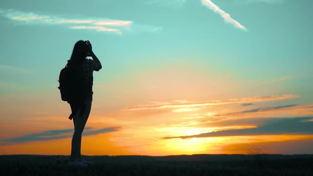 silhouette Hipster hiker silhouette girl is shooting video of beautiful nature sundown on cell telephone smartphone slow motion video. Female tourist is taking photo with mobile phone camera. female