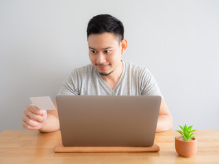 Man is happy using credit card for digital payment.