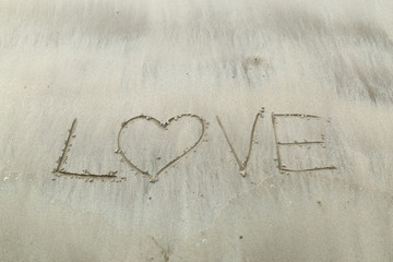Writing letter love on sand.