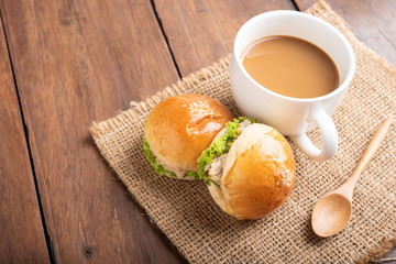 tuna burger and coffee on wood background.