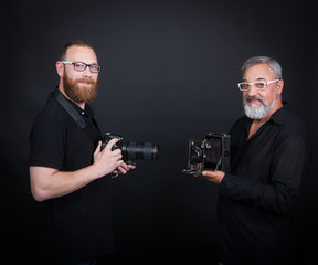 Two male photographers, young and elderly, with cameras - modern digital and vintage widescreen. On...