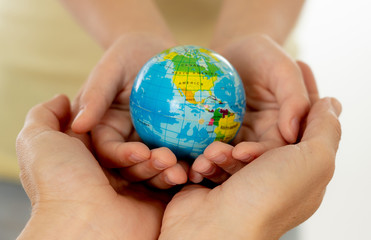 mother and daughter holding world globe in eduction and protecti