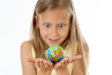 Pretty young blonde girl in yellow blouse looking at small globe i