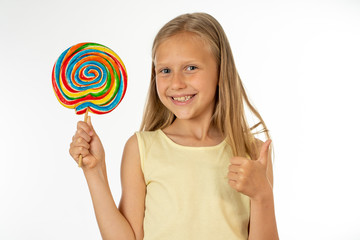 Beautiful little girl eating lollipop on white background