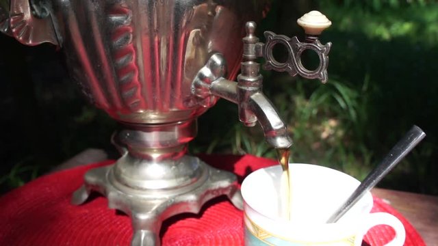 Man Pouring Tea From Russian Kettle "samovar" Outdoors