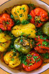 Red and yellow bell stuffed paprika peppers with meat with greens