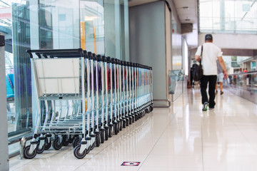 Obraz premium empty pushcart in airport. man walking on background