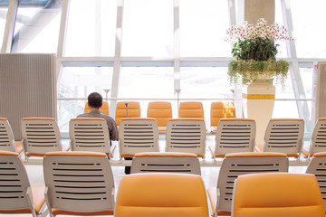 Caucasian man waiting departure at airport on the bench