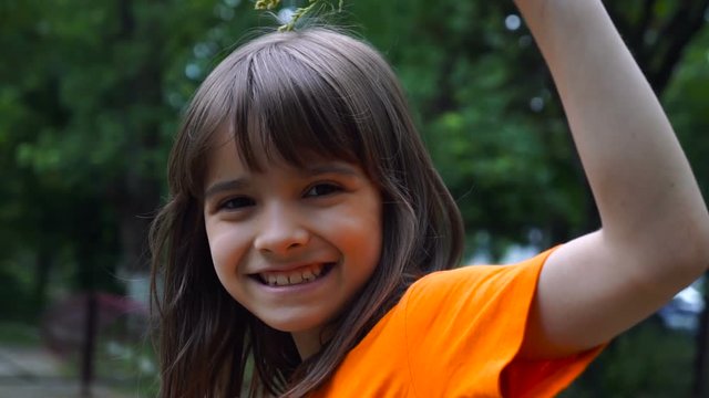 Cheerful Smiling Girl In A Garden. Close up portrait of litle girl.