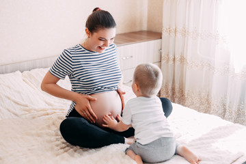pregnant woman playing and hugging with her second baby