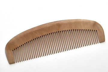 closeup brown wooden comb on a white background