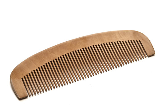 closeup brown wooden comb on a white background