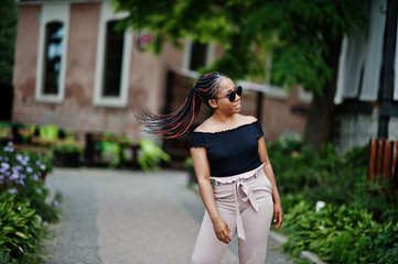 Stylish african american woman at sunglasses posed outdoor.