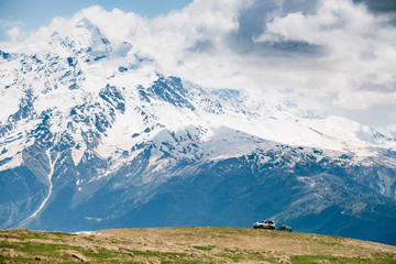 Obraz premium Beautiful snow-covered mountains of Georgia and SUV
