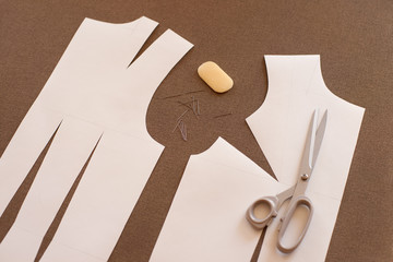Pattern of the basis of clothing for sewing. Paper pattern of dress on fabric. Tailoring scissors,...
