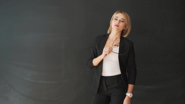 the business woman teacher with glasses and a suit. Put on and adjust the glasses before class