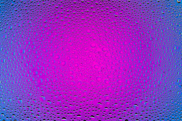 Close up of a water drops on a purple and blue gradient background, covered with drops of water...