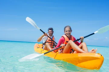 Foto op Canvas Happy girl and her father kayaking at tropical sea on yellow kayak © Max Topchii