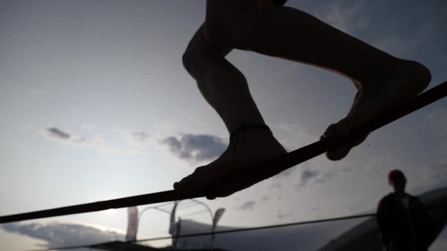 Young girl legs silhouette walking balancing on slackline rope the modern sport activity