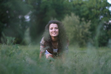 Fototapeta na wymiar Young, beautiful woman on nature. Young woman with dark curly hair.