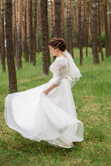 Obraz na płótnie Canvas A beautiful bride in wedding dress is dancing alone outdoor