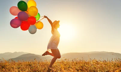 Fotobehang happy woman with balloons at sunset in summer © JenkoAtaman