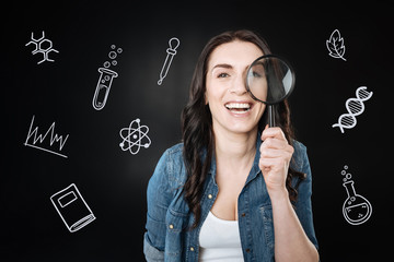 Funny science. Cheerful emotional student wearing casual clothes and smiling while standing with a...