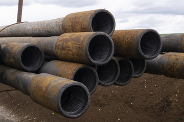 Oil Drill pipe. Rusty drill pipes were drilled in the well section. Downhole drilling rig. Laying the pipe on the deck. View of the shell of drill pipes laid in courtyard of the oil and gas warehouse.