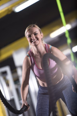 athlete woman doing battle ropes cross fitness exercise