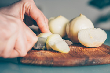 The cook cuts the onion on a cutting board