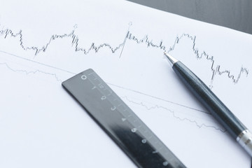 Financial graphs analysis and pen.