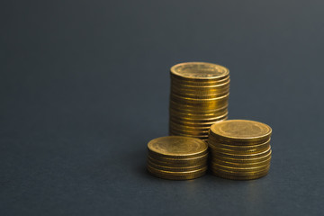 Savings, increasing columns of coins, piles of coins arranged as a graph in dark room, business banking concept.