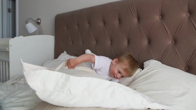 Parents having fun with their little daughter on bed. Family spending time at the morning