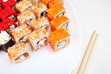 Sushi set on a white plate. Several varieties of sushi and chopsticks. Japanese traditional food.